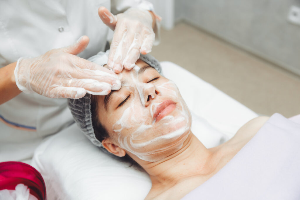 the cosmetologist cleanses the skin with foam.